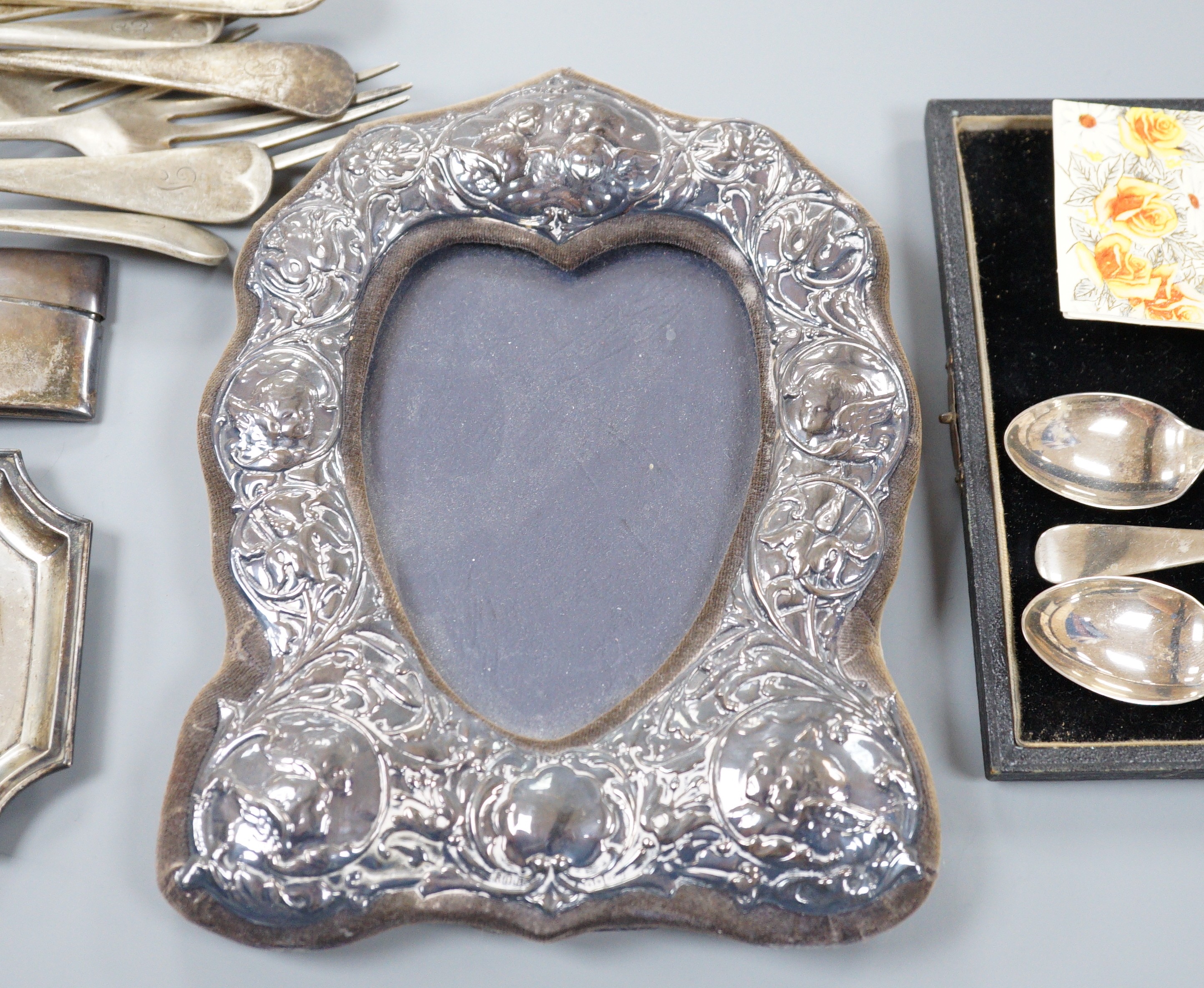 A mixed collection of silver to include cutlery, napkin rings, photograph frame, card cases, small dish, etc.